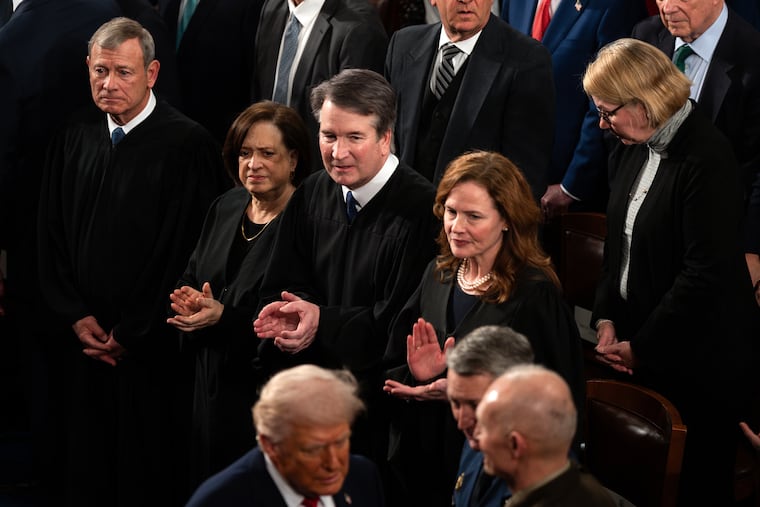 President Donald Trump walks by Chief Justice John Roberts, Justice Elena Kagan, Justice Brett Kavanaugh, and Justice Amy Coney Barrett as he greets Chairman of the Joint Chiefs of Staff General Dan Caine on the House floor to give his State of the Union address to a joint session of Congress, at the Capitol in Washington, Tuesday, Feb. 24, 2026.