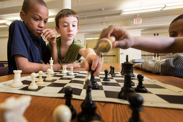 Derrick Moore, 10, left, and Jacob Martin, 10, play chess at Kingsessing Library in Philadelphia on April 7, 2015. ( LAURENCE KESTERSON / For the Daily News )