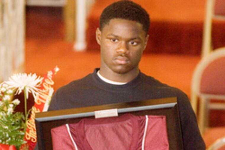 A mourner (left) at New Hope Temple Baptist Church yesterday displays Tykeem's jersey from James Alcorn Elementary's middle-school annex, where Tykeem had completed 7th grade.