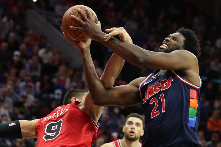 Joel Embiid, right, of the Sixers gets fouled by the Bulls' Nikola Vucevic during a game at the Wells Fargo Center on Nov. 3, 2021.