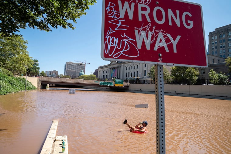 Austin Ferdock drinks a beer while floating in floodwater that continues to rise over the submerged Vine Street Expressway, Interstate 676, following a storm amid the remnants of Hurricane Ida, on September 2, 2021, in Philadelphia.