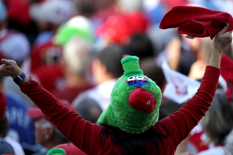 A Phiilies fan with a Phanatic hat celebrates during their win over the Braves. Tickets for the NLCS against the San Diego Padres went on sale Monday morning, but quickly sold out.