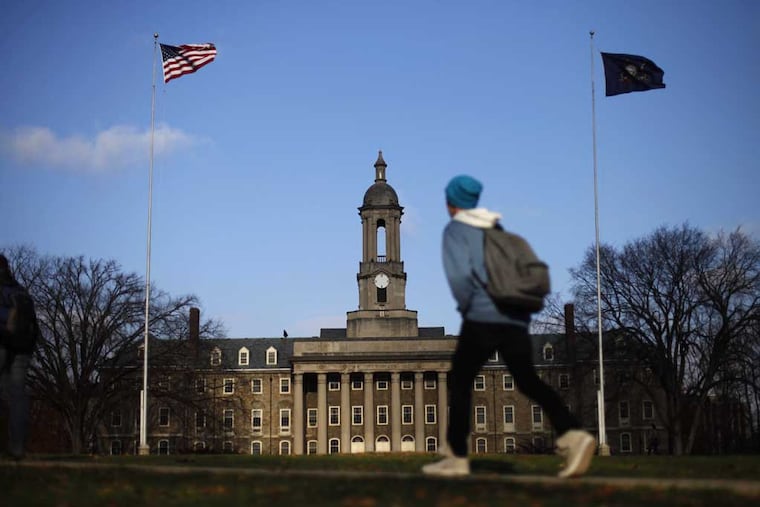 A student walks in front of the Old Main building on the Pennsylvania State University campus. (AP Photo/Matt Rourke)