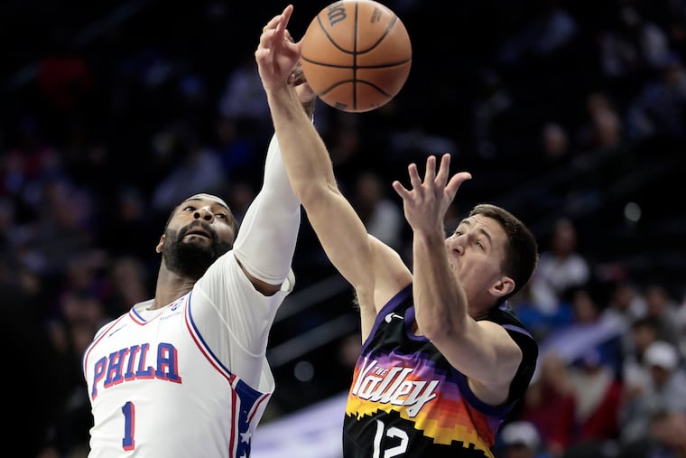 Sixers center Andre Drummond, battling for a loose ball with the Suns' Collin Gillespie, has shared fluctuating time with big man Adem Bona.