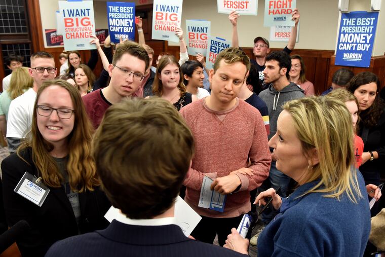 Matthew Current (back to camera), from Clinton, Iowa, and a supporter of former Mayor Pete Buttigieg, tries to persuade other caucus-goers to align with his candidate at a satellite caucus at Penn (from left): Jessica Anderson, from Titonka, who organized the caucus; Patrick Weiss and Chris Page, both from Iowa City; and Mary Thompson, from Johnston, in Philly on business.