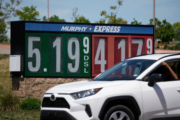 Gasoline prices are displayed outside a convenience store as a motorist drives by, Thursday, May 26, 2022, in Thornton, Colo. Experts are expecting a flush of travelers at airports and on the nation's byways during the long Memorial Day weekend, which marks the start of the summer travel season, in spite of high fuel costs.