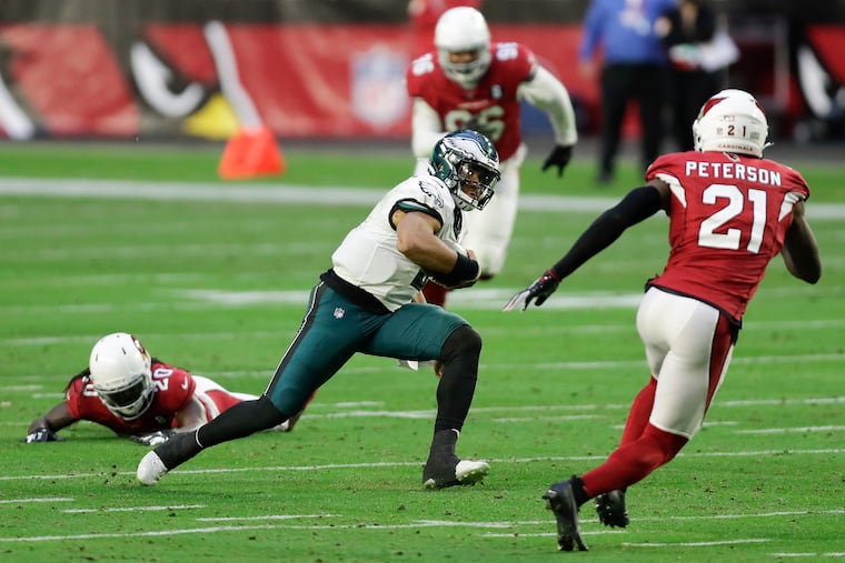 Eagles quarterback Jalen Hurts runs past Arizona Cardinals cornerback Dre Kirkpatrick (left) and against cornerback Patrick Peterson on fourth-and-six play during the third quarter on Sunday, in Glendale, Arizona.