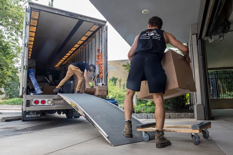 John Wulffen (right) and Fred Meder of EverSafe Moving load in furniture into their moving truck on a Thursday in July.