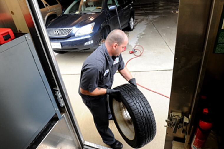 Jeff Prickett, assistant area manager for TireVan, a D.C.-area company that has set up shop here, unloads a tire. (Sharon Gekoski-Kimmel / Staff Photographer)