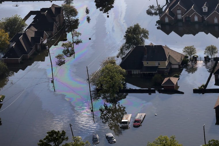 Petroleum spill off is seen emanating from flooded vehicles in the aftermath of Tropical Storm Harvey in Beaumont, Texas, Thursday, Aug. 31, 2017.
