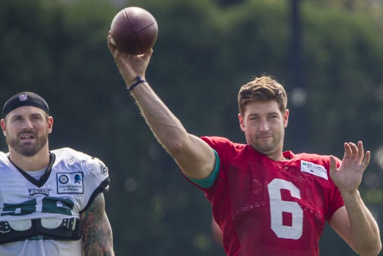 Eagle defensive end Chris Long, left, watches Dolphins quarterback Jay Cutler, right, warm up prior to their combined practice on Monday.
