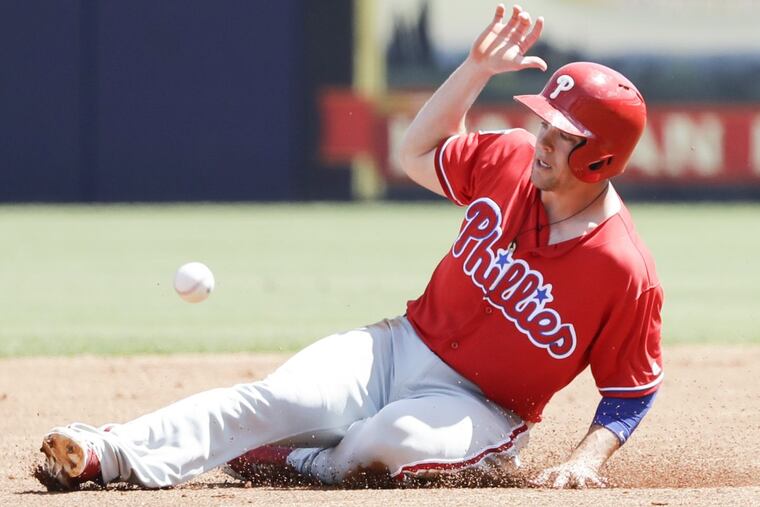 Scott Kingery slides past the baseball near second base during a spring training game.