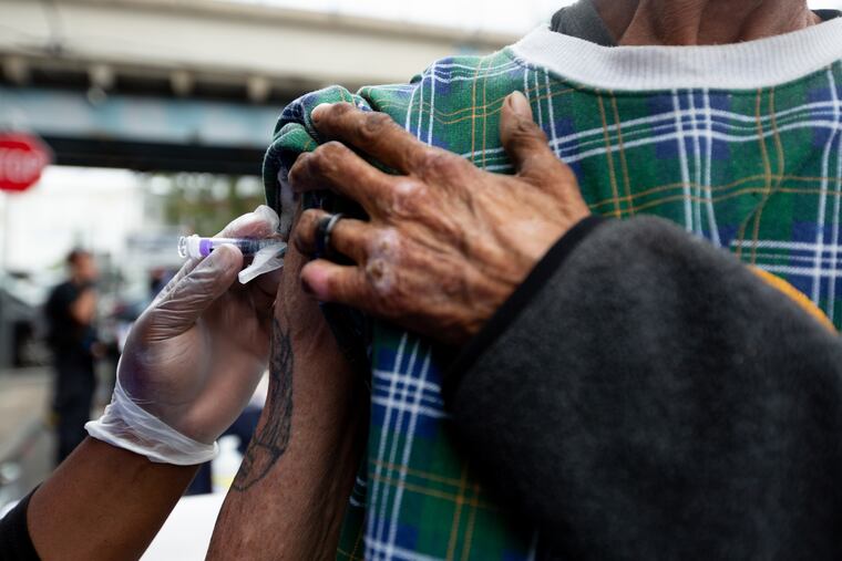 Mecca Taylor, of Philadelphia's department of Public Health, administers a free Hepatitis A shot to Marvin Nowling outside Prevention Point Philadelphia in Kensington Wednesday, August 28, 2019. Prevention Point Philadelphia and 30 partner organizations provided food, Narcan overdose reversal kits, Hepatitis and HIV tests, and a wide variety of services and resources from organizations across the city, all for free at a neighborhood block party.