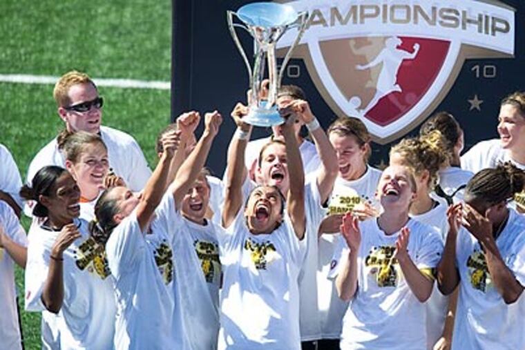 FC Gold Pride star Marta lifts the Women's Professional Soccer championship trophy. (John Todd/ISI Photos)