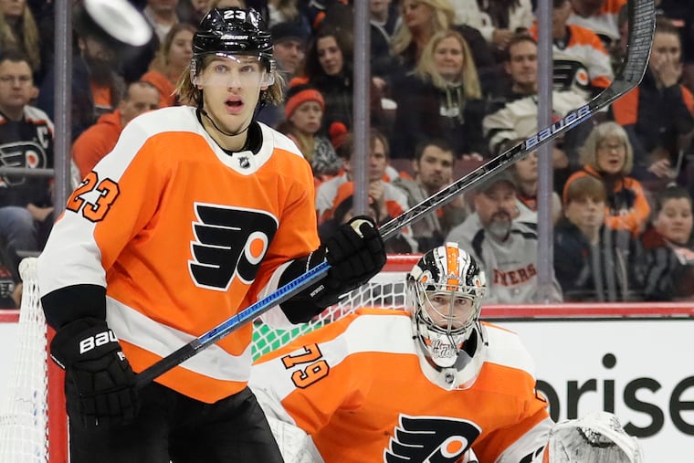 Flyers left wing Oskar Lindblom and goaltender Carter Hart watch the flying puck during the second-period against the Pittsburgh Penguins on Monday, February 11, 2019 in Philadelphia.