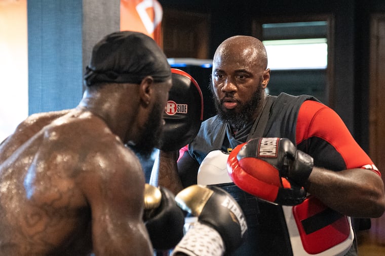 Malik Scott, right, trains former heavyweight champion Deontay Wilder. Scott, a North Philadelphia native who had a 38-3-1 professional career.