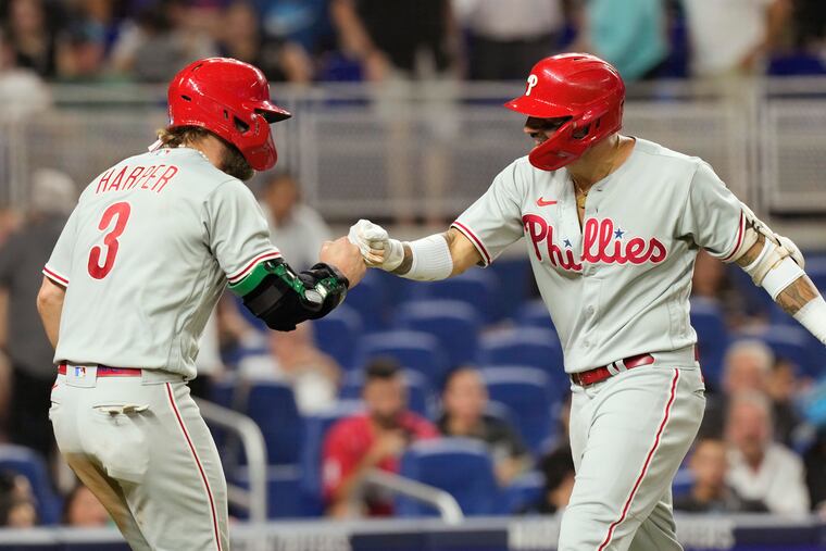 The Phillies' Bryce Harper congratulates Nick Castellanos after Castellanos hit a two-run home run to take the lead in the ninth inning against the Marlins on Tuesday.