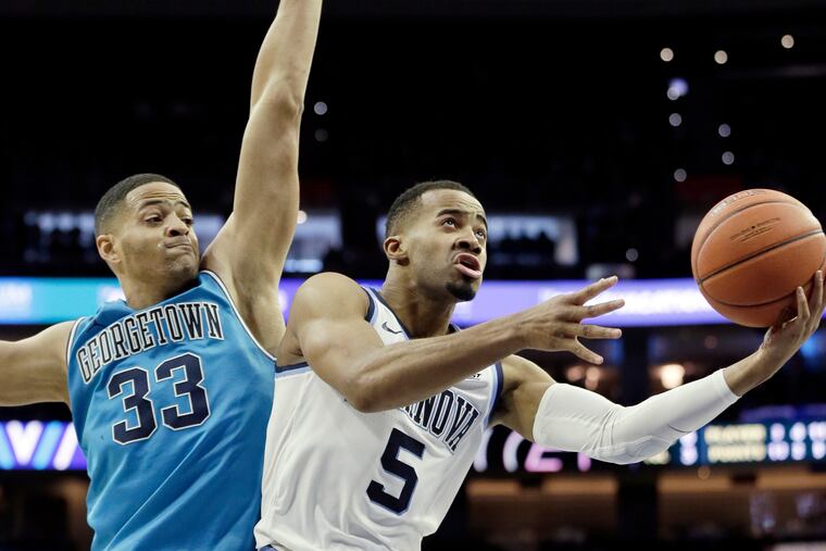 Villanova #5 Phil Booth shoots around Georgetown’s # 33 Trey Mourning in the 2nd half of the Georgetown vs. Villanova University NCAA mens basketball game at Wells Fargo Center in Phila., Pa.on February 3, 2019.