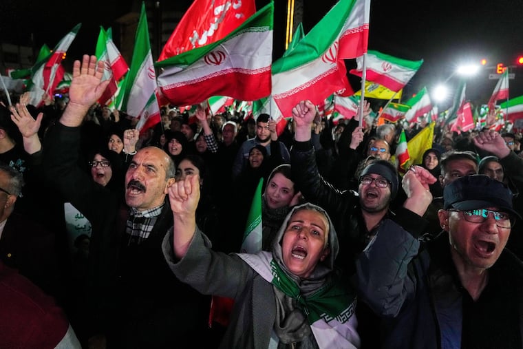 Pro-government supporters chant slogans and wave Iranian flags during a rally, in a square in western Tehran, Iran, on Wednesday.