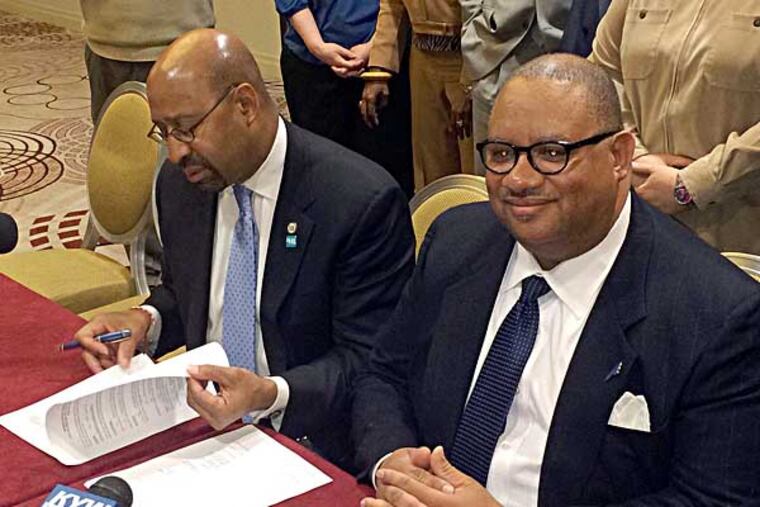 Mayor Nutter and District Council 47 President Frederick Wright prepare to sign the first new contract for the city's white-collar workers in five years after reaching an agreement Tuesday. Photo by Troy Graham, staff)