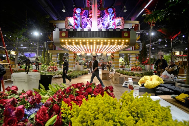 Workers from Valley Forge Flowers work on the Art Deco theater facade in the entryway Thursday, February 26, 2015 as they prepare for opening of Philadelphia Flower Show and its 2015 theme - "Celebrate the Movies."