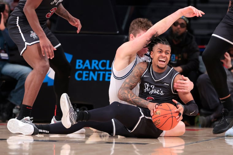 Erik Reynolds II of St. Joseph's comes up with a loose ball against Neal Quinn of Richmond during a quarterfinal game in the Atlantic 10 Basketball Tournament on Thursday.