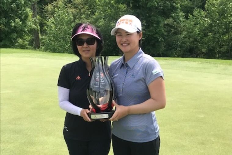Min Lee, winner of the Valley Forge Invitational, shares the trophy with her mother, Tsui Fen Chung.
