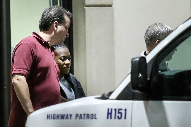 Carlesha Freeland-Gaither is escorted from Howard County General Hospital in Columbia, Md. early Thursday morning by Philadelphia Detectives James Sloan (left) and John Geliebter (partially obscured).