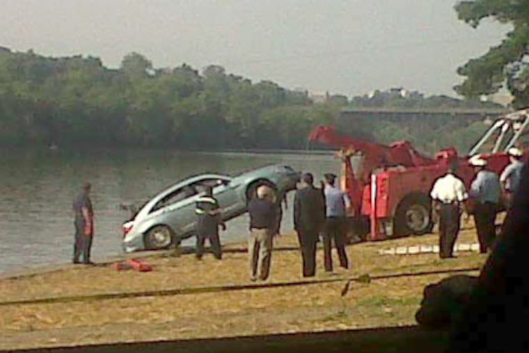 A tow truck pulls a car Tuesday from the Schuylkill River along Kelly Drive near Strawberry Mansion Bridge. The driver, a Philadelphia police officer, was killed. (Photo courtesy of NBC-10)