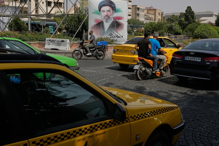 Vehicles pass a banner showing a portrait of the Iranian Supreme Leader Ayatollah Mojtaba Khamenei, in downtown Tehran, Iran, Monday, Aug. 31, 2026.