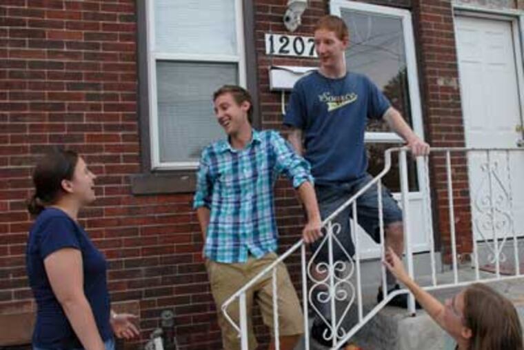 College grads who live in Camden. Joshua Dupuis, a Franciscan volunteer, second from left, talks to his roommates Colleen McTammany, left, and Tom Firme, top right. At bottom right is Jennifer Midura. ( April Saul / Staff Photographer )