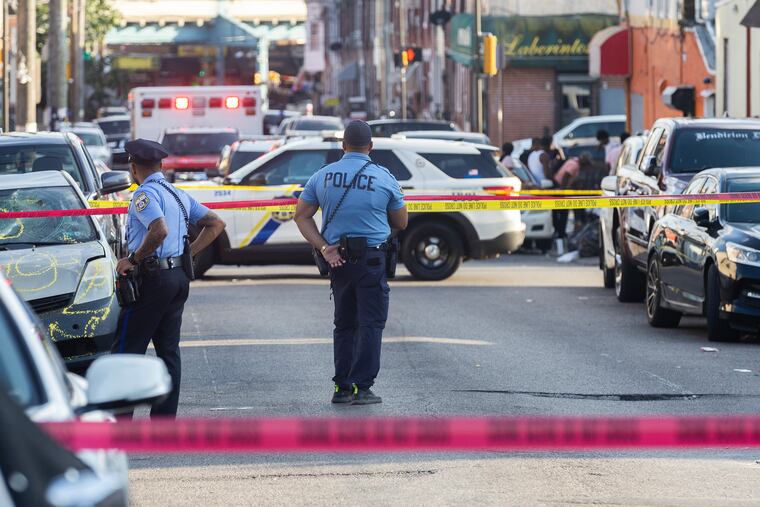 Police officers at a crime scene at the intersection of G and Madison Streets in August.