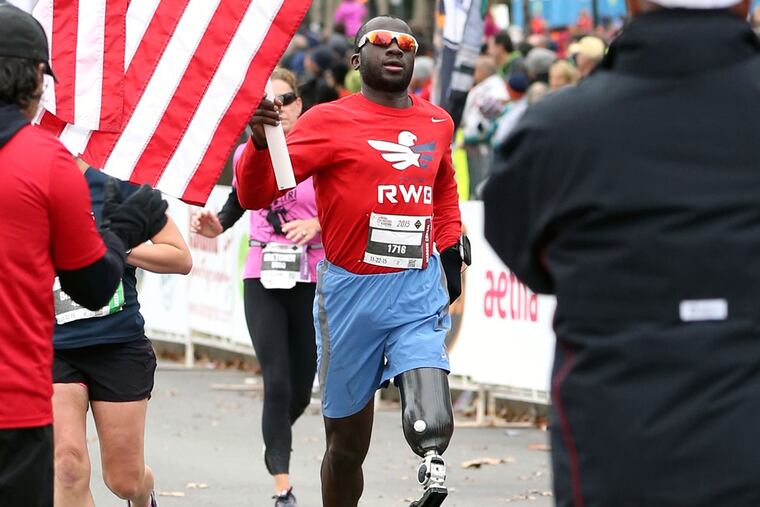 William Reynolds ran with an American flag for the last mile of the Philadelphia Marathon, his first with a prosthetic leg.