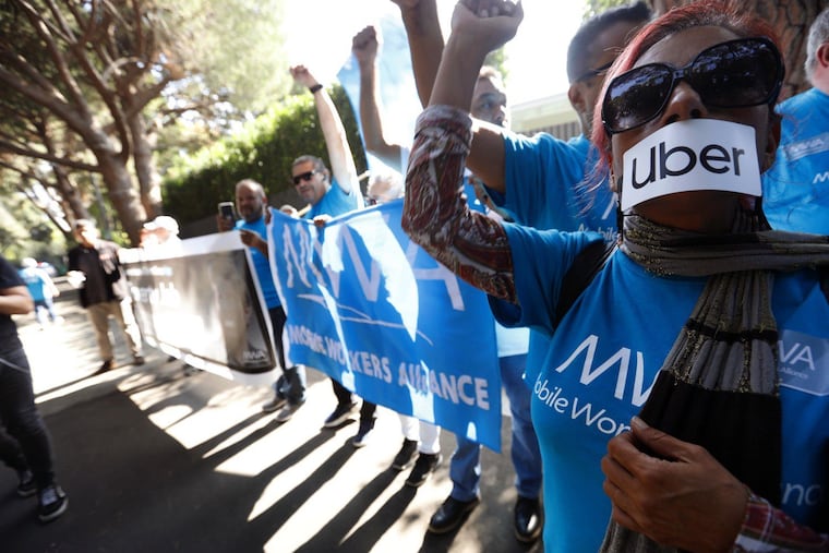 Uber and Lyft driver Teresa Mercado (right) joins members of the Mobile Workers Alliance, which consists of Uber and Lyft drivers, protesting at the home of Uber co-founder Garrett Camp in Beverly Hills.