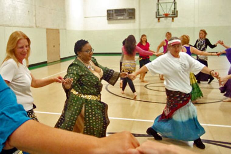 Students travel in a "grapevine" in Deborah Anderson's belly dancing class at a community center in Tacoma, Washington. (Peter Haley / Tacoma News Tribune / MCT)