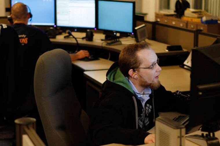 Tom Cowling, a police dispatcher, sits at the same computer where dispatcher Jeannine Moore took the call from a Lindenwold police officer on December 25 that started the gift giving drive. South Jersey police and dispatchers played Santa Claus and delivered gifts Tuesday to a Lindenwold family whose gifts were stolen during a burglary around 1 a.m. Christmas morning.( MICHAEL S. WIRTZ / STAFF PHOTOGRAPHER ).