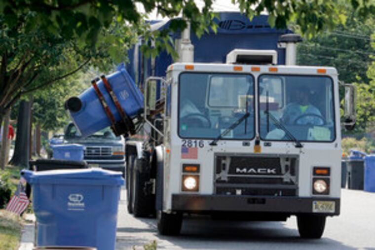 Doug Sims, a driver for Republic Services of New Jersey LLC, picks up recycling bins on Knollwood Drive in Cherry Hill. After a successful test run in a few neighborhoods, the entire town decided to embrace the RecycleBank program.