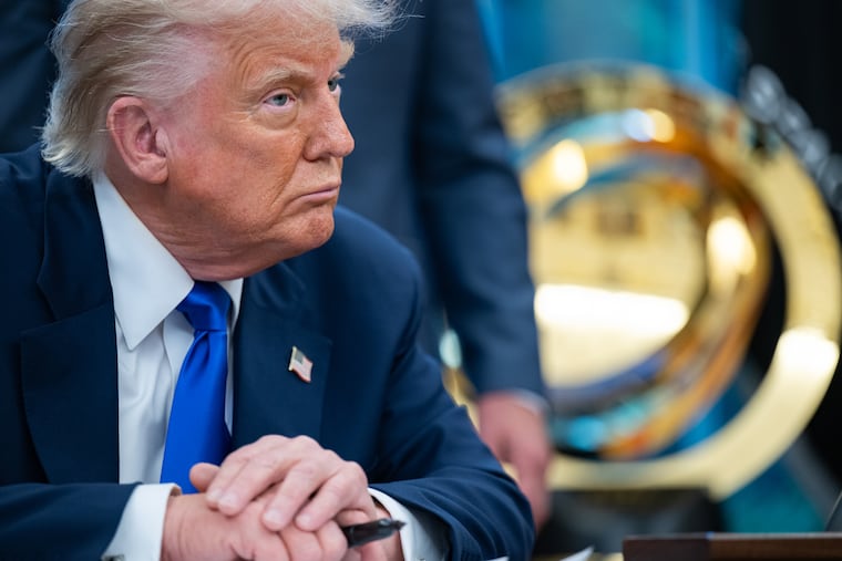 President Donald Trump signs executive orders in the Oval Office of the White House on Monday.