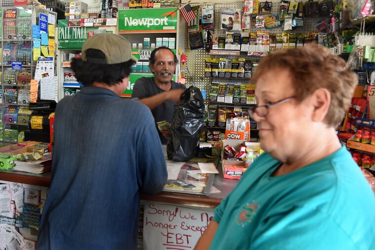 Charlie Mused, the Yemeni immigrant owner of Charlie’s convenience store in Scranton, S.C., is behind the counter as off-duty mail carrier Bonnie Lee (right) hangs around after making her purchase.