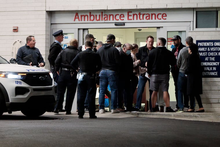 Philadelphia police gather at Penn Presbyterian Medical Center, where an undercover officer was brought for treatment of injuries from flying debris when someone shot at his car near the 8000 block of West Brunswick Avenue in Southwest Philadelphia shortly after 2 a.m. Saturday.