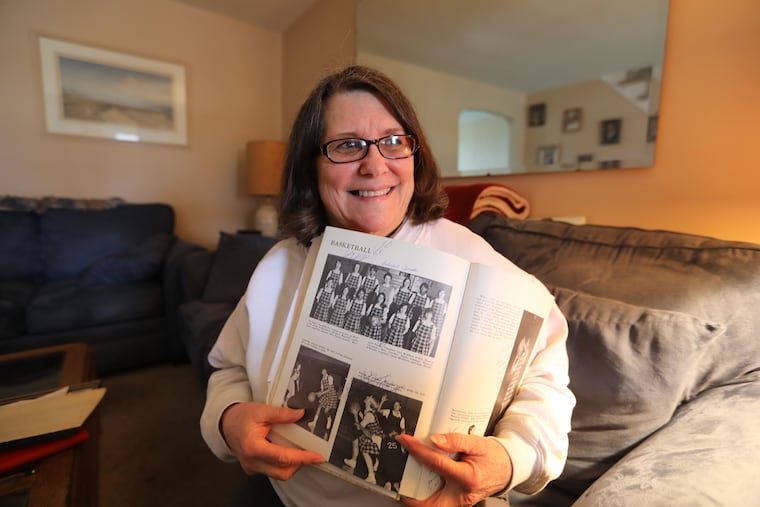 Mary Croydon Lee, a 1968 graduate, shows the girls' basketball page of her West Catholic High School yearbook.