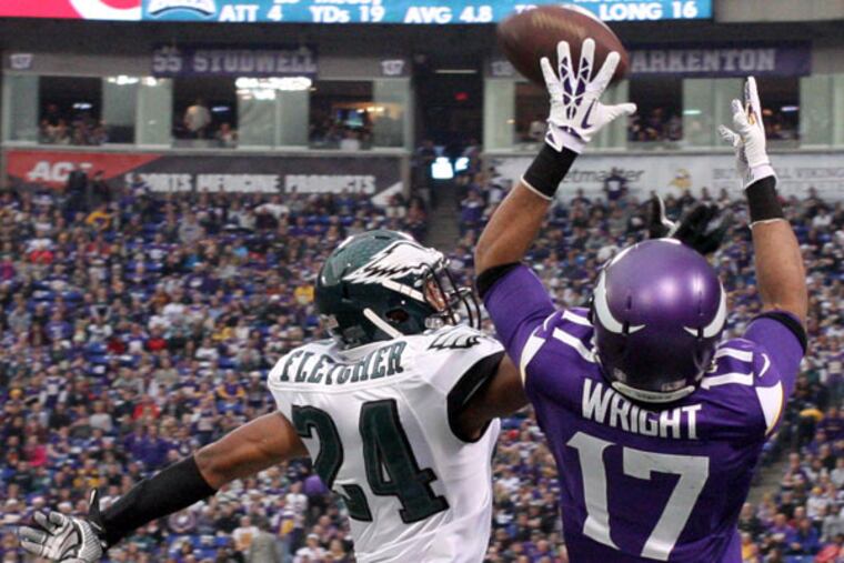 The Vikings' Jarius Wright catches the ball over Bradley Fletcher in the third quarter. (Yong Kim/Staff Photographer)