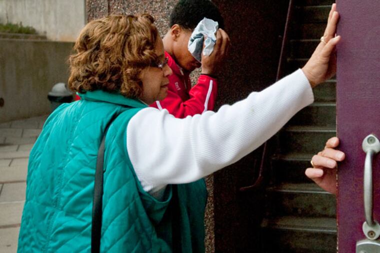 Winston-Salem State University Police Chief Pat Norris, left, holds the door open for Winston-Salem State quarterback Rudy Johnson as he enters a magistrate's office Friday, Nov. 14, 2013. Winston-Salem State Chancellor says a Virginia State football player faces assault charges after a bathroom fight left Johnson badly beaten during a luncheon for both teams on the eve of their championship game. (AP Photo/Winston-Salem Journal, Lauren Carroll)