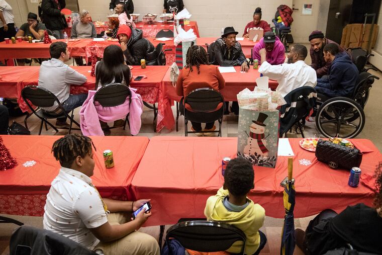 A room full of people attend the gunshot survivors group holiday party at the Carousel House in West Philadelphia on Monday, Dec. 16, 2019.