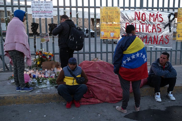 Migrants stand near an improvised altar after spending the night outside the immigration detention center where 38 migrants died during a fire in Ciudad Juarez, Mexico on March 29, 2023.