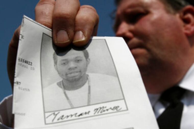 Yeadon Police Chief Donald Molineux talks to reporters and holds a photo of shooting suspect Tamarr Minor, 21. He was arrestedin Philadelphia yesterday several hours after an apartment manager and a constable were shot while serving Minor an eviction notice at the Parkview Court Apartments in Yeadon. Helicopters and dogs helped in the search, and the suspected weapon was recovered.