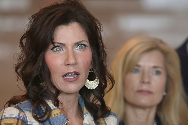 South Dakota Gov. Kristi Noem (left) at a news conference in March.