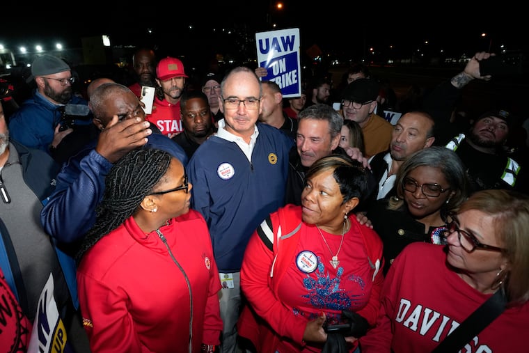 United Auto Workers President Shawn Fain stands with UAW members striking at Ford's Michigan Assembly Plant in Wayne, Mich., early Friday.
