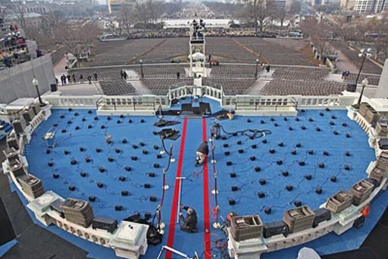 Workers put the finishing touches on the stage where Barack Obama will be sworn in as President. (Michael Bryant / Staff Photographer)