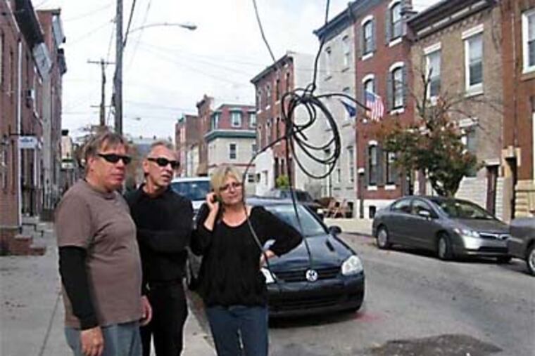 Fishtown residents (from left) Gary Preston, Al Muzychka and Aileen Staffieri check out the dangling wires.